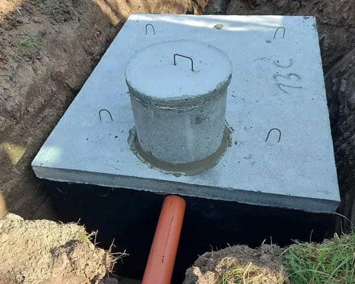 Zbiornik betonowy z doprowadzeniem rury w wykopie